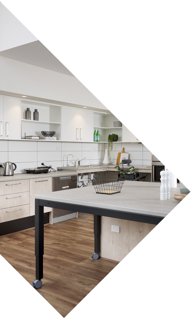 A stylish SDA approved kitchen appointed with custom features and wooden floors.